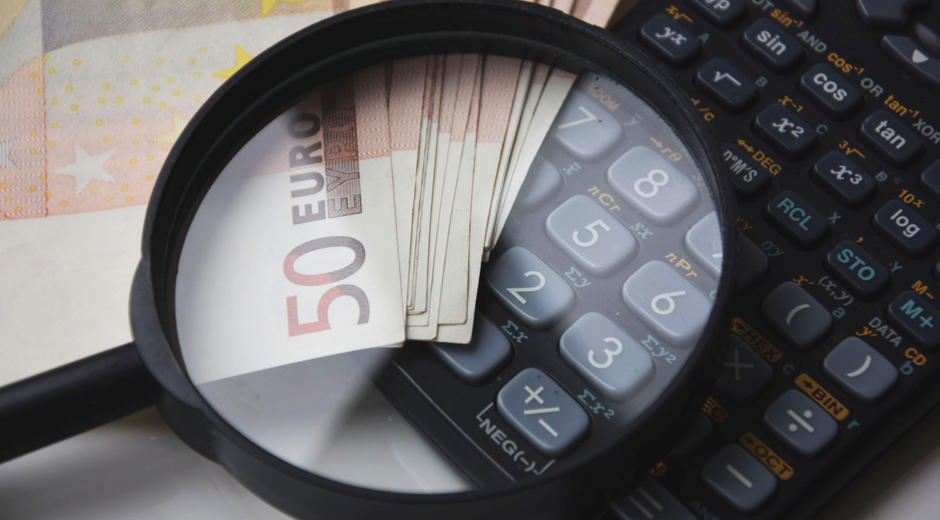 Euro bills under magnifying glass with calculator, symbolizing finance and analysis.