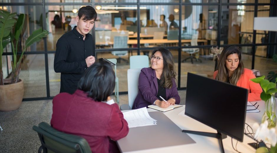 Colleagues engage in a meeting within a modern office, promoting teamwork and productivity.